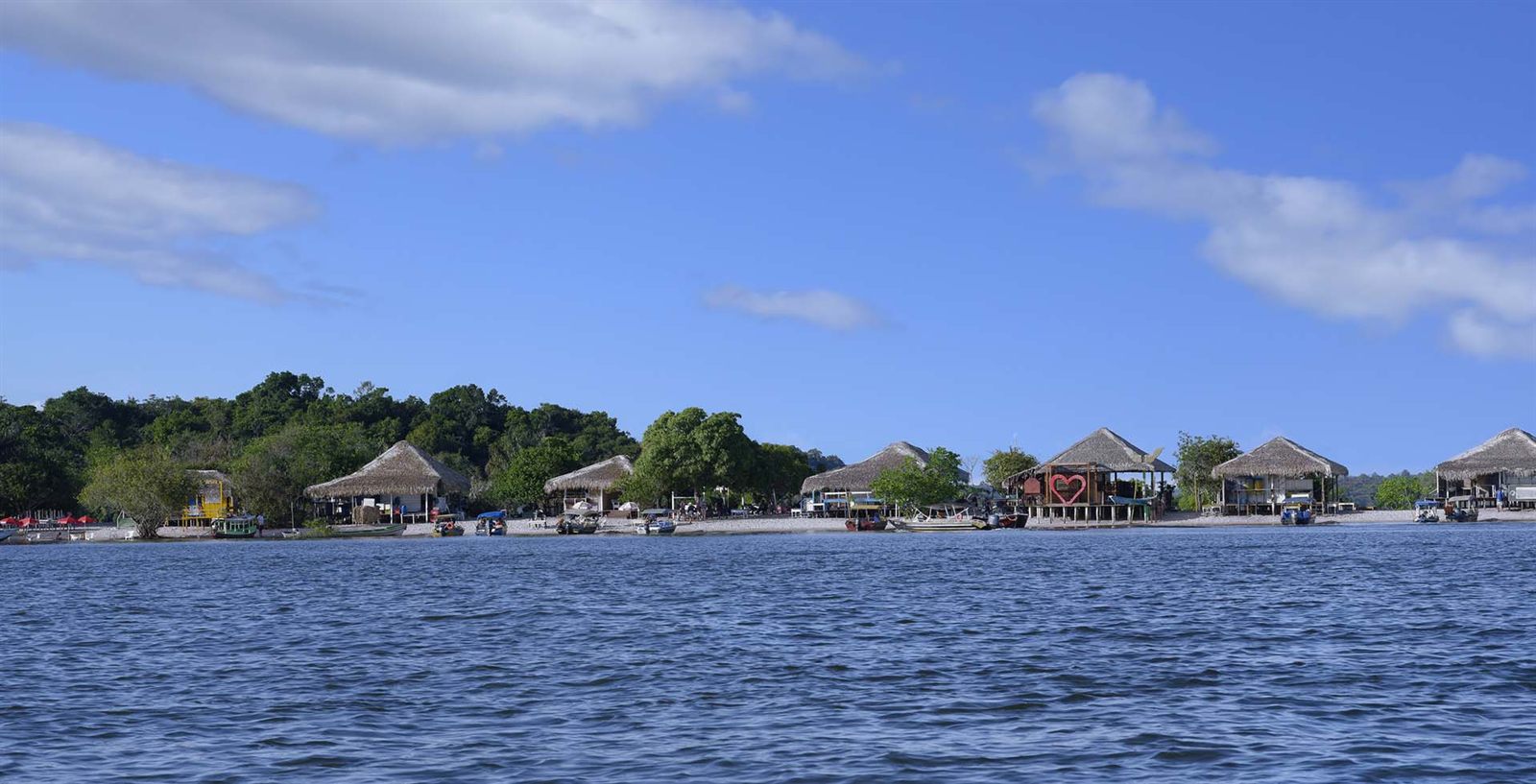 Thatched riverside buildings on the bank of the Amazon